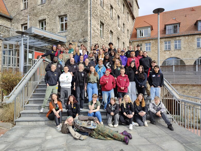 Zu sehen sind alle Teilnehmenden des BUNDI auf der Eingangstreppe der Burg Feuerstein. 