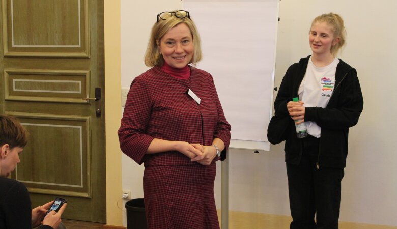 Zu sehen sind Caro (LHR Mitglied) und Frau Rauscher Mitglied des Bayerischen Landtags, die gemeinsam vor einer weißen Flipchart stehen. 